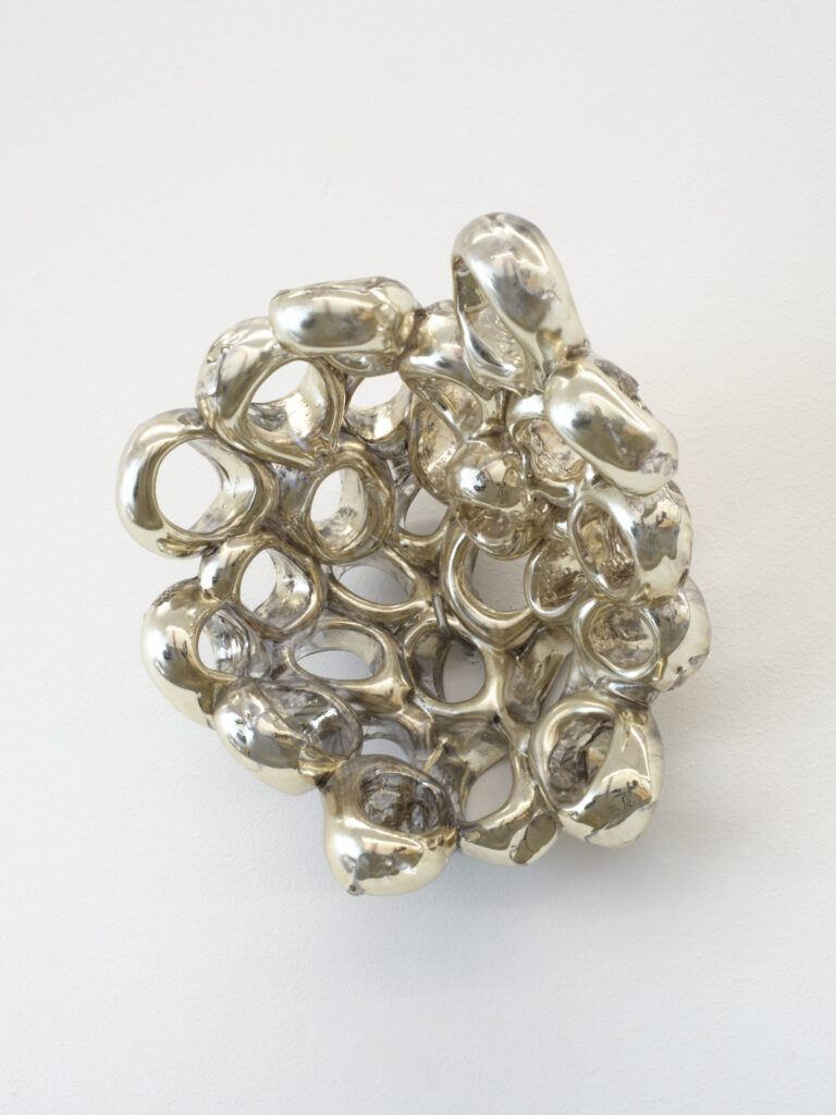 A cluster of mirrored rings protruding off of the wall. 