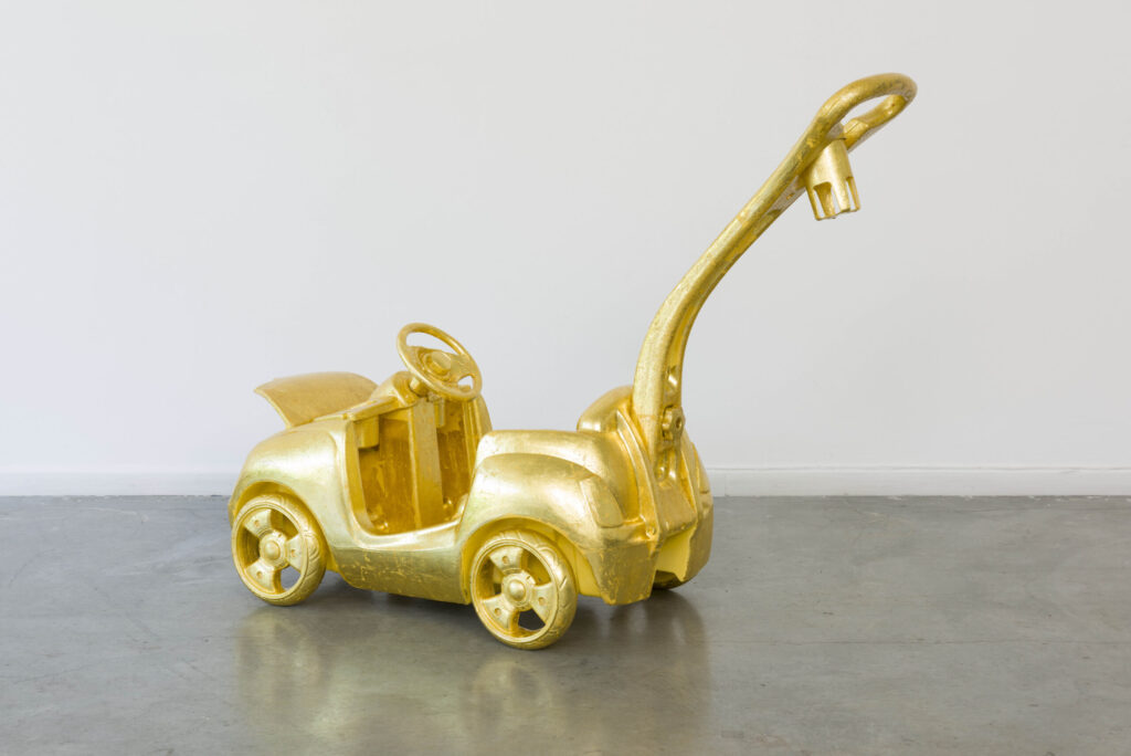 Image of a toddler's push car that has been covered with gold leaf.