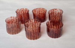 six blown glass cups speckled with red