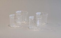 four clear blown glass cups with a pattern of bubbles on the surface