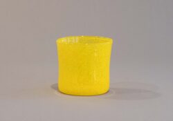 One single yellow blown glass cup
