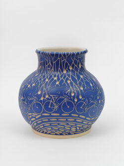 Lymphatic III
2022 A large blue wheel-thrown ceramic vessel that has a wide round shoulder and comes to a smaller opening at the top with a white interior. The surface is carved with images of a bicyclist riding around the center of the pot. Surrounding the cyclist are patterns of lymphatic vessels.