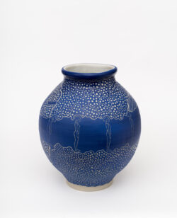 Muscular III
2022 A large blue wheel-thrown ceramic vessel that has a wide round shoulder and comes to a smaller opening at the top with a white interior. The surface is carved with images of a woman doing a forward bend surrounded by patterns representing muscles.