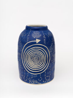 Neural II
2022 A large blue wheel-thrown ceramic cylinder that comes to a smaller opening at the top with a white interior. The surface is carved with two spirals on either side of the vessel. Filled in around the spirals are carvings of acupressure points and paths of the body.