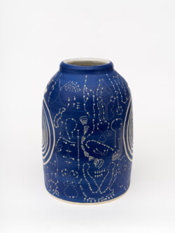Neural II
2022 A large blue wheel-thrown ceramic cylinder that comes to a smaller opening at the top with a white interior. The surface is carved with two spirals on either side of the vessel. Filled in around the spirals are carvings of acupressure points and paths of the body.