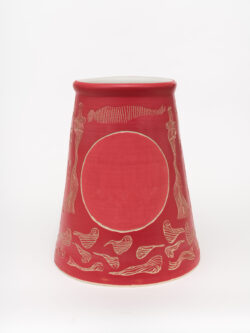 Circulatory II
2022 A large red wheel-thrown ceramic cylinder that is wider at the bottom with a white interior. The surface has been carved with images of lines representing breath and there are two large circles that are a softer red on either side of the vessel.