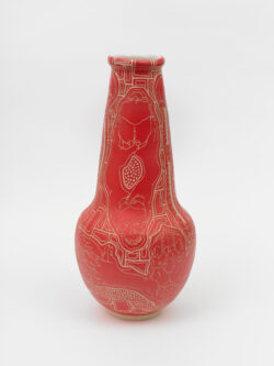 Skeletal III
2022 A red wheel thrown ceramic vessel that is wider at the bottom, has a long conical neck and a white interior. The surface has intricate carvings of hands holding a skull in various positions representing different Cranial Sacral holds.