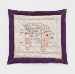 Body II 2022 A colorful embroidered diagram of a reflexology chart of the foot. It is on a quilted white background with a purple frame and gold thread accenting the outline.