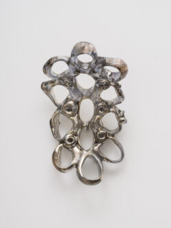 Untitled (Spirit 9) 2023 A cluster of mirrored rings protruding off of the wall. Resembling something found in the ocean or on a molecular scale.
