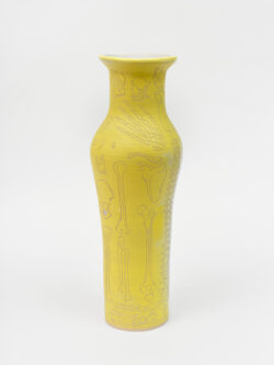 Skeletal I
2022 A tall, yellow wheel-thrown ceramic vessel that has a wider round shoulder and comes to a smaller opening at the top, much like a bottle, with a white interior. The surface is carved with diagrams of the skeletal system.