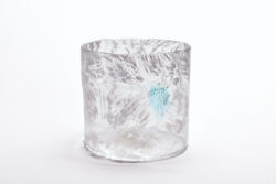 Large glass cylinder with white fuzzy feather like lines through out the surface. There is one splotch blue.