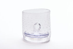 Large blown glass cylinder with a pattern of small bubbles throughout the surface. Inside of the vessel is a solid glass weight with a ring as a handle.