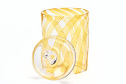 Large blown glass cylinder with orange stripes throughout. Leaning against the side is a solid glass weight with a ring on the top as a handle.