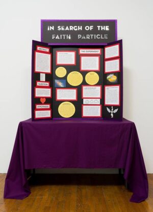 A science fair like presentation of information about the large hadron collider. It is sitting on a table with a maroon table cloth.